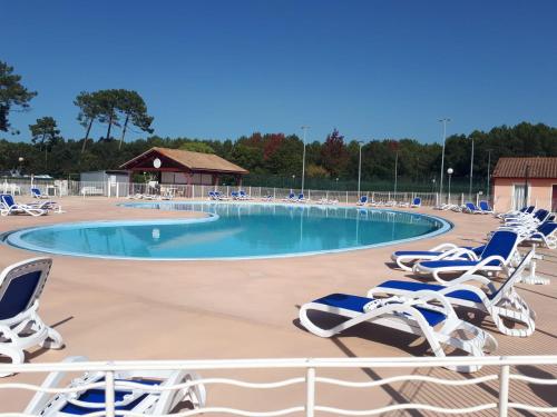 - une piscine avec des chaises longues dans un complexe dans l'établissement chalet Le Ticaco Soustons plage, à Soustons