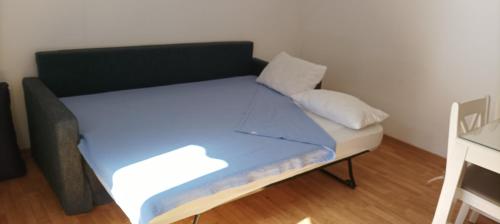 Cama en habitación con colchón y almohadas azules en chalet Le Ticaco Soustons plage, en Soustons