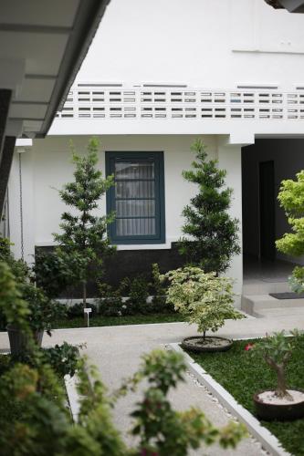 a white house with trees in front of it at CERIA HOTEL at Alun Alun Yogyakarta in Yogyakarta