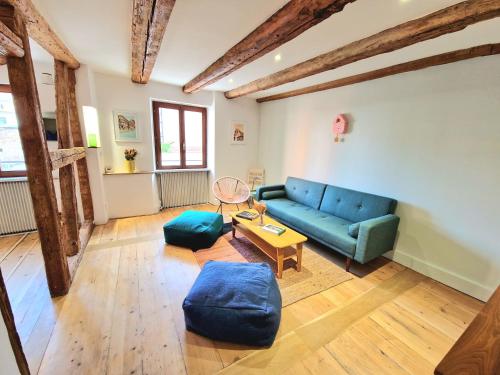 a living room with a blue couch and a table at Home La Petite Porte - Petite Venise - Colmar in Colmar