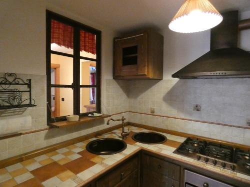 a kitchen with two sinks and a stove and a window at Au Coeur de Saint Nicolas in Saint Nicolas