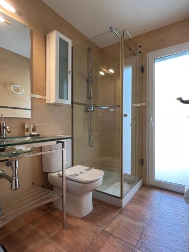 een badkamer met een toilet en een glazen douche bij Villa Manzanera in Calpe