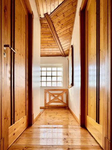 a hallway of a house with wooden floors and a window at Casa do Rio Alva in Arganil