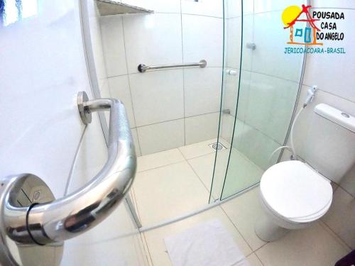 a bathroom with a toilet and a glass shower at Pousada Casa Do Angelo in Jericoacoara