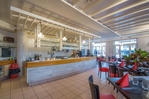 un restaurant avec un bar, des tables et des chaises dans l'établissement Hôtel de ville du Sentier, à Le Sentier