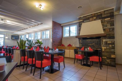 a restaurant with red chairs and tables in a room at Hôtel de ville du Sentier in Le Sentier