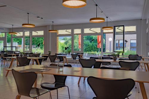 un ristorante con tavoli, sedie e finestre di The Lab Capsule a Thun