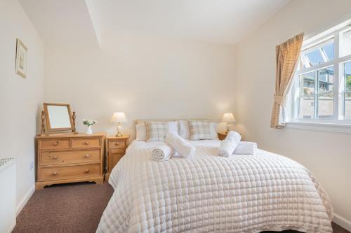 Schlafzimmer mit einem Bett mit weißer Bettwäsche und einem Fenster in der Unterkunft Cottage 8 Old Farmhouse braithwaite in Keswick