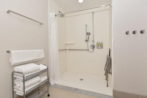 a white bathroom with a shower and a towel rack at Holiday Inn Express & Suites Charlotte - Ballantyne, an IHG Hotel in Charlotte