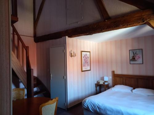 - une chambre avec un lit, un escalier et une table dans l'établissement Hôtel des Cymaises, à Semur-en-Auxois