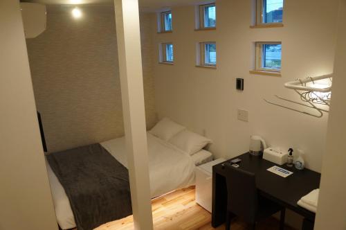a small room with a bed and a desk at SORAYADO 宙宿 in Tsuru 