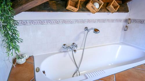 uma banheira branca com um chuveiro na casa de banho em NEW! Suite Apartment em Castelnuovo del Garda