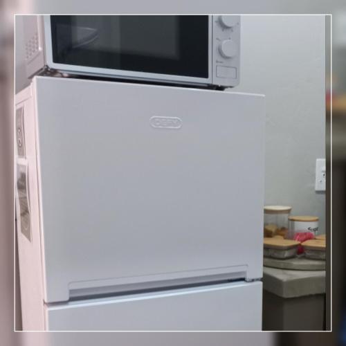 a microwave sitting on top of a refrigerator at A-Cody Place in Louis Trichardt