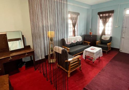uma sala de estar com um sofá e um espelho em Aradhya Apartments em Darjeeling