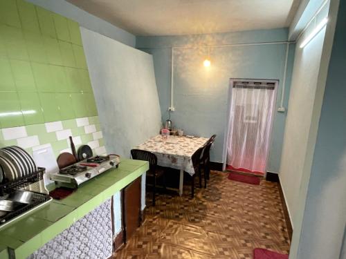 uma cozinha com uma mesa e uma mesa e uma mesa; em Aradhya Apartments em Darjeeling