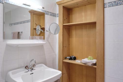 a white bathroom with a sink and a mirror at Pension Landhaus Gasteiger in Kitzbühel