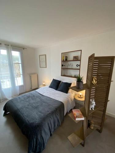 une chambre avec un grand lit et une grande fenêtre dans l'établissement Studio +++ très agréable en centre ville, à Doué-la-Fontaine
