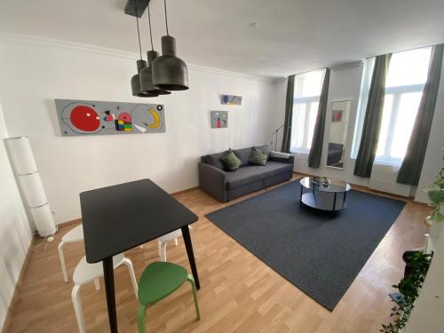 a living room with a black table and a couch at appartement hyper centre ville in Arras