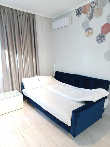 a bed with a blue frame in a room at Tara Deluxe Apartment in Varna City