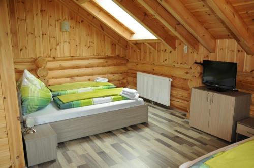 ein Schlafzimmer mit einem Bett und einem TV in einer Hütte in der Unterkunft Ferienhaus Stoiser in Pruggern