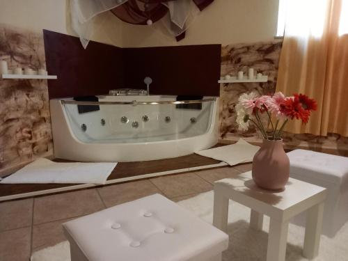 ein Badezimmer mit einer Badewanne und einer Vase aus Blumen in der Unterkunft Villa Laura Apartment in Giardini-Naxos