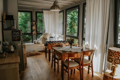 uma sala de jantar com uma mesa e algumas janelas em Pokoje Gościnne Wysoka em Świeradów-Zdrój