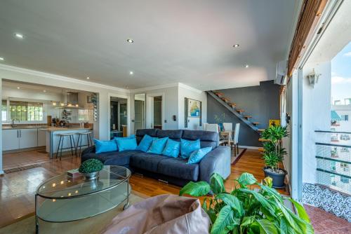 un soggiorno con divano blu e una cucina di Ático Bellas Vistas a Torremolinos