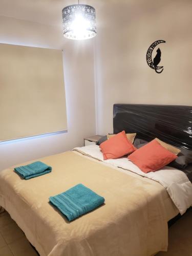 1 dormitorio con 1 cama con 2 toallas en La Casita de Lujan en Luján de Cuyo