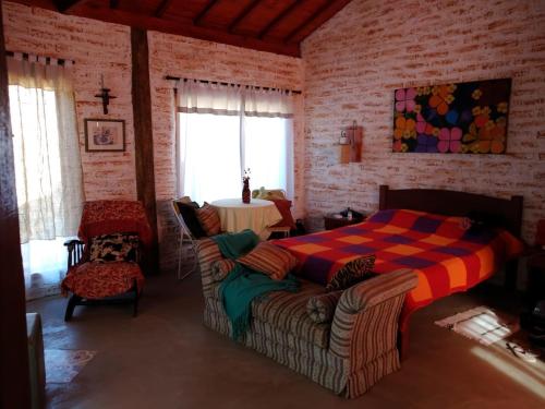 a bedroom with a bed and a table in a room at Chalé charmoso com vista p/ Montanha - Gonçalves in Paraisópolis