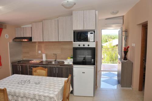 a kitchen with a table and a microwave at EVA in Gornji Karin