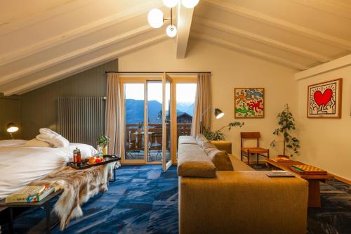 une chambre d'hôtel avec un lit et un canapé dans l'établissement Shed HOTEL, à Verbier