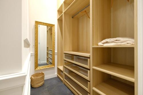 a dressing room with wooden cabinets and a mirror at Suite la Duchesse et Parking privé gratuit in Mons