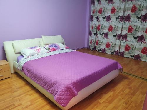 1 dormitorio con 1 cama con edredón morado en Crema Apartaments, en Ploieşti