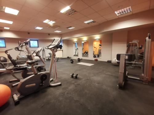 un gimnasio con cintas de correr y elípticas en una habitación en Aparthouse Zegrze en Serock