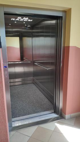 a large metal refrigerator in a room with a floor at Apartament W sam Raz in Słupsk