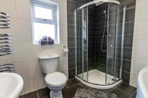 La salle de bains est pourvue d'une douche, de toilettes et d'un lavabo. dans l'établissement Westfield 3 Bed Characterful and Modern House FREE PARKING and private garden, à Mansfield