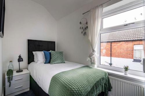 a white bedroom with a bed and a window at Westfield 3 Bed Characterful and Modern House FREE PARKING and private garden in Mansfield