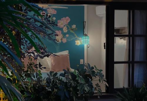 a room with a couch and a wall with flowers at Villa Balthazar in Búzios