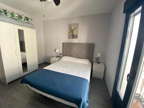 um quarto com uma cama com um cobertor azul em Apartamento Jazmín em Ardales