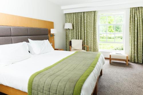 Un dormitorio con una cama grande y una ventana en Champneys Henlow en Henlow