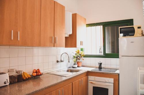 a kitchen with a sink and a white refrigerator at Single Fin Hostel in Arona