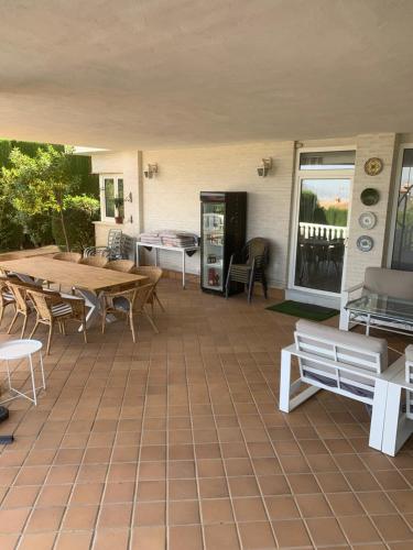 a patio with tables and benches on a house at Villa Mare a los pies de Sierra Nevada in Granada