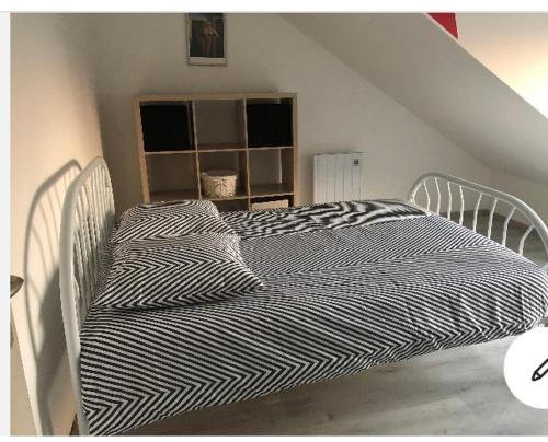 ein weißes Bett in einem Zimmer mit Dachgeschoss in der Unterkunft Les coteaux vue mer in Criel-sur-Mer