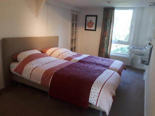 um quarto com 2 camas e uma janela em familiehuis Amber em Haaksbergen