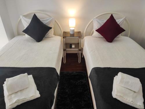 duas camas lado a lado em um quarto em Alojamento Local Tamega em Amarante