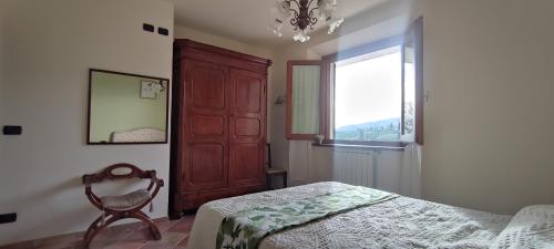 a bedroom with a bed and a window and a chandelier at PETTOCANNELLA in Massa e Cozzile
