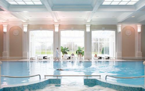 einen Pool in einem großen Zimmer mit einem großen Fenster in der Unterkunft Champneys Henlow in Henlow