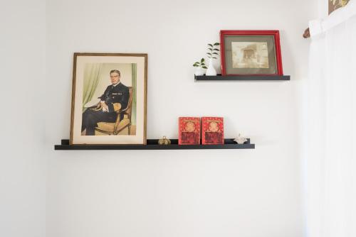 two shelves on a wall with portraits of a man at Villa Balthazar in Búzios