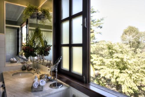 a bathroom with a sink and a large window at Villa Balthazar in Búzios