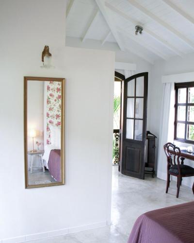 a mirror on a white wall in a bedroom at Villa Balthazar in Búzios